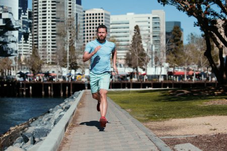 Foto de Joven atlético corriendo en la naturaleza. Correr en parque de la ciudad - Imagen libre de derechos