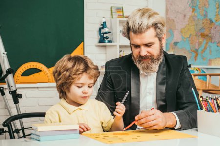 Photo for Homework help. Father helping his son to make homework. Elementary school. Pupil learning letters and numbers - Royalty Free Image