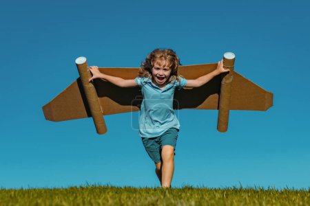 Photo for Child boy playing with cardboard toy airplane wings craft in sky with copy space for text. Creative with family and dreaming of flying concept. Travel and imagination concept - Royalty Free Image