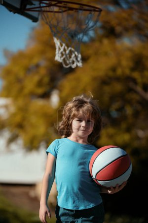 Téléchargez les photos : Un gamin qui joue au basket. Mode de vie actif des enfants - en image libre de droit