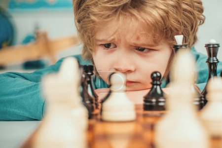 Photo for Son are playing chess and smiling at home. Kids chess school. Little clever boy thinking about chess - Royalty Free Image
