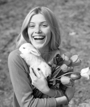 Téléchargez les photos : Belle femme tenant un lapin blanc. Portrait de jeune femme posant avec un lapin. Joyeuse Pâques - en image libre de droit