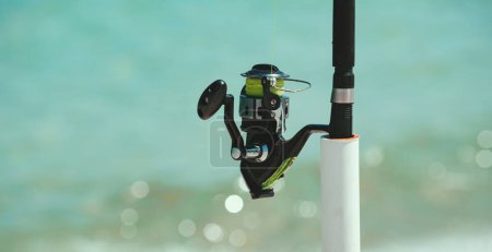 Photo for Summer vacation. Fishing rod at sea. Spinner, fish-rod. Relaxing seascape - Royalty Free Image