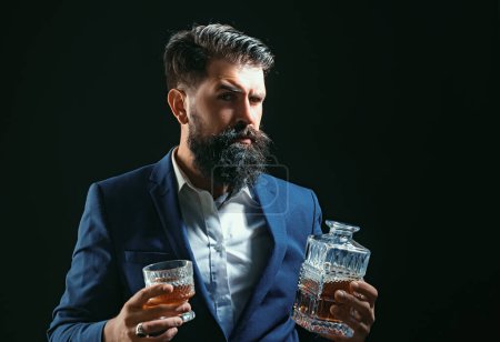 Téléchargez les photos : Élégant élégant barbu homme barman tient verre de whisky - en image libre de droit