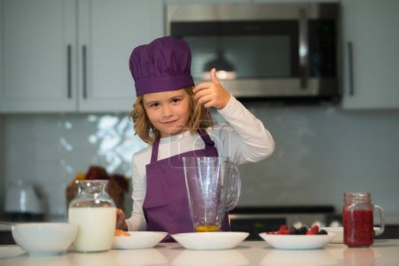 Photo for Chef child cooking. Child chef cook is learning how to make a cake in the home kitchen - Royalty Free Image