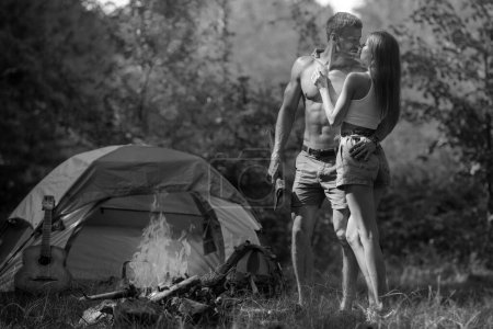 Foto de Sexy pareja de camping cerca de fondo del bosque. Concepto naturaleza y estilo de vida. Amantes románticos en el campo - Imagen libre de derechos
