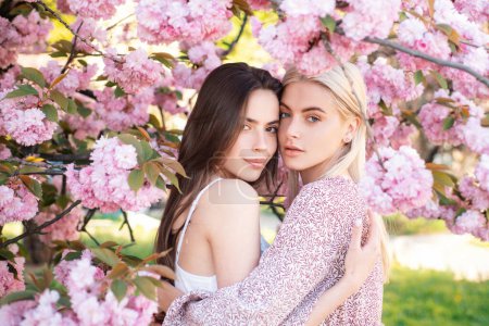 Foto de Dos jóvenes sensuales mujeres sexy relajarse en flores de sakura - Imagen libre de derechos