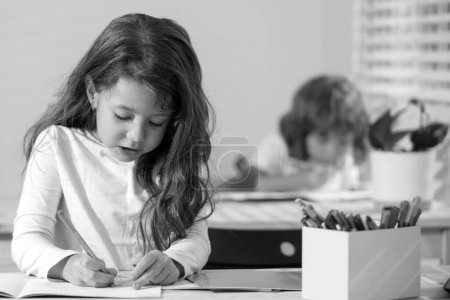 Téléchargez les photos : Enfants, fille mignonne dessin dans la salle de classe à l'école - en image libre de droit