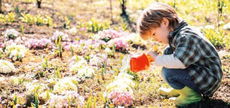 Foto de Actividad de jardinería con un niño pequeño. Me gusta pasar tiempo en la granja. Pequeño niño jardinería y divertirse en el patio de primavera - Imagen libre de derechos