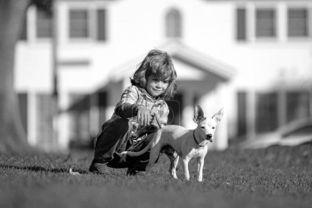 Foto de Niño y perro mascota. Niño paseo con cachorro - Imagen libre de derechos