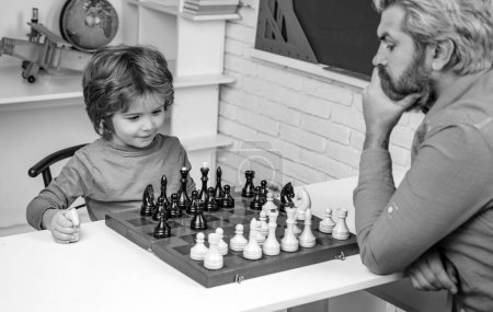 Foto de Día de los Padres. Niño concentrado desarrollando estrategia de ajedrez. Inteligente niño concentrado y pensante mientras juega al ajedrez - Imagen libre de derechos