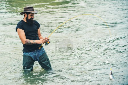 Téléchargez les photos : Un homme attrapant du poisson. Loisirs et loisirs. La vie est toujours meilleure quand je pêche. Fisher a une longue tige. Week-end d'été. Voler poisson passe-temps de l'homme. Pêche au gros - en image libre de droit