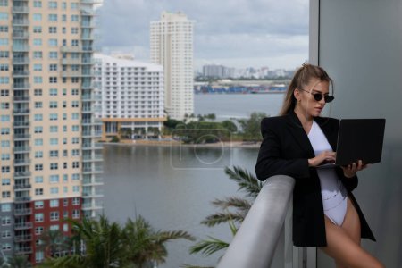 Photo for Sexy confident business woman wearing a fashion business outfit suit. Young female director, startup business, own online business. Balcony city view - Royalty Free Image