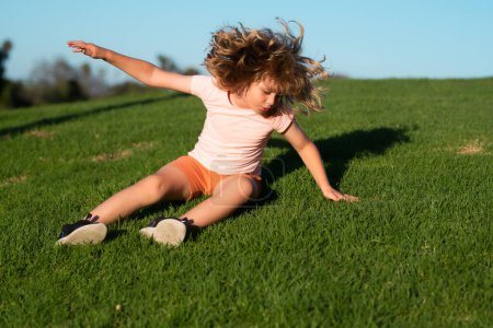 Photo for Child running tripped and falls down. Kid runs through the spring grass and falling down on the ground in park. Fall risk for children. Injured, safety, dangerous and incident concept - Royalty Free Image
