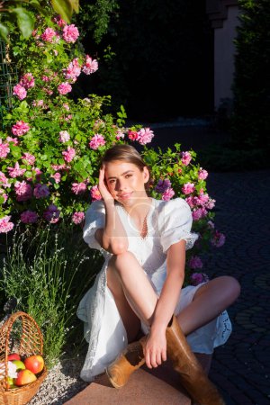 Photo for Beautiful sexy girl near rose flower in spring park. Young woman in flowering garden with roses. Beauty model with spring flowers. Happy spring. Pretty woman enjoying smell flowers in spring park - Royalty Free Image