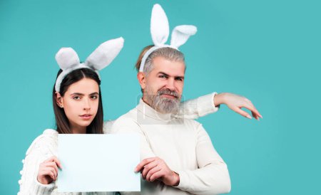 Photo for Easter bunny man and woman hold board board for text. Banner with funny bunny couple, copy space - Royalty Free Image