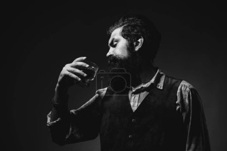 Téléchargez les photos : Homme élégant et élégant dans l'usure classique tenant verre avec wiskey à la main - en image libre de droit