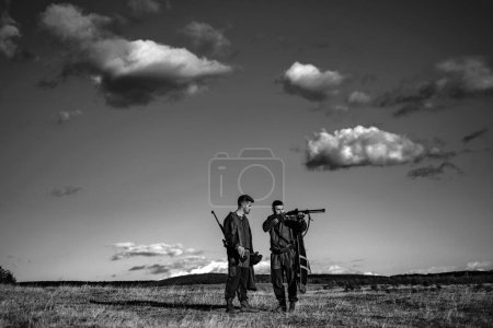 Foto de Cazadores con escopeta a la caza. cazador hombre sosteniendo arma y caminando en el bosque - Imagen libre de derechos