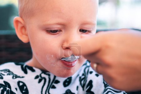 Photo for Kid food. Feeding baby boy with spoon. Fatherhood, mother or sister with child - Royalty Free Image
