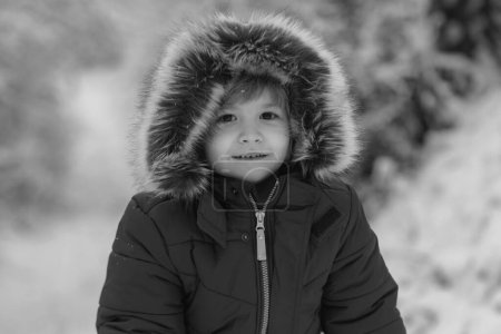 Foto de Un niño pequeño en el campo de nieve. Ropa de invierno para niños. Concepto invierno Niños y naturaleza. Recuerdos de la infancia - hermoso invierno nevado sobre el prado - Imagen libre de derechos