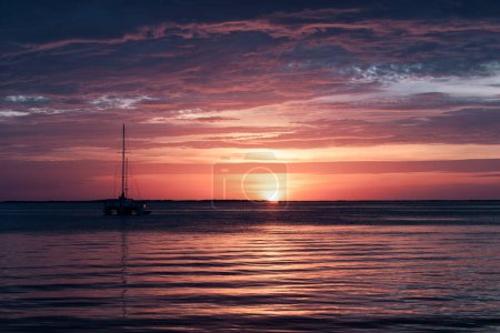Photo for Sunset or sunrise in ocean, nature landscape background. Pink clouds flying in sky to shining sun. Evening or morning view - Royalty Free Image