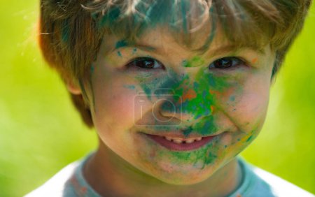 Foto de Niño del festival Holi. Cara graciosa de niño pintado. Niño juega con los colores - Imagen libre de derechos