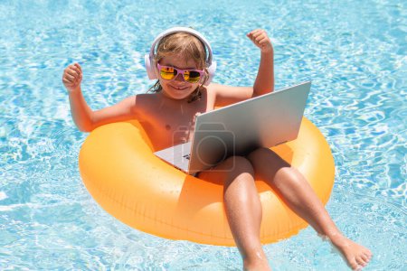 Photo for Work outside with laptop in pool. Kid remote working on laptop in pool. Little business man working online on laptop in summer swimming pool water - Royalty Free Image