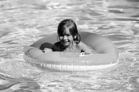 Foto de Feliz niño jugando con anillo de flotador de natación en la piscina. Vacaciones de verano. Estilo de vida saludable para niños - Imagen libre de derechos