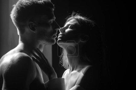 Photo for Couple in love face to face, tender hugging and kissing. Beautiful woman and handsome man boyfriend. Beautiful loving couple posing on dark backgroung with night lights - Royalty Free Image