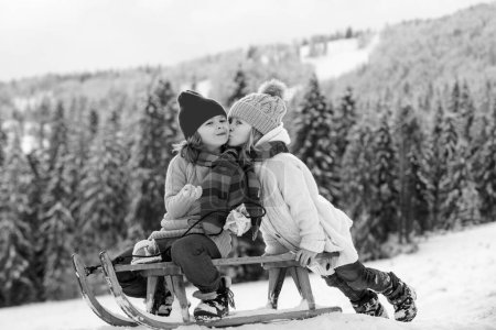Téléchargez les photos : Joyeuses enfants d'hiver. Le bonheur et l'amour des enfants. Un baiser de couple. Enfant embrassé - en image libre de droit