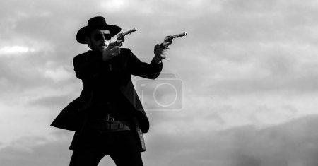 Photo for American cowboy shooting. Handsome brutal western guy. Sheriff with wild west guns, vintage pistol revolver and marshal ammunition. American western. Wild west with cowboy - Royalty Free Image