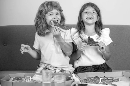 Foto de Niños hambrientos comiendo pizza. Niña y niño comen pizza - Imagen libre de derechos