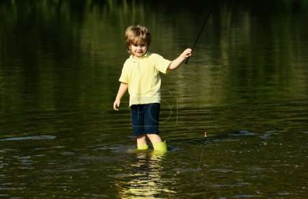 Foto de Niño de pie en el río con caña de pescar en el día soleado. Lindo chico está pescando en el río en el verano. Lindo niño pescando en estanque - Imagen libre de derechos