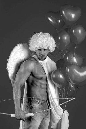 Foto de Día de San Valentín. Ángel macho sexy. Flecha de amor. Hombre atleta guapo con alas de ángeles. Cupido, amour, Cupido. 14 de febrero. Aislado sobre rojo - Imagen libre de derechos