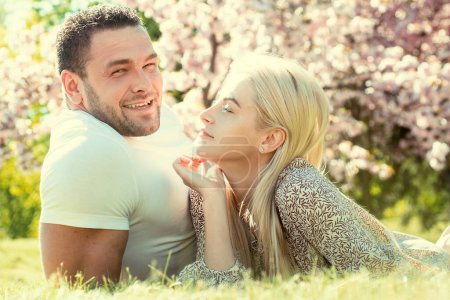 Téléchargez les photos : Beau jeune couple profitant d'un jardin fleuri. Couple affectueux de tendresse. Famille heureuse - en image libre de droit
