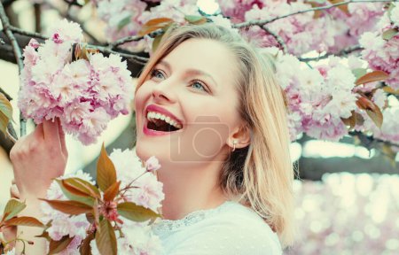 Foto de La idea y el concepto de mujeres felices en el Día Internacional de la Mujer. Mujer feliz con árbol Sakura floreciente y día soleado - Imagen libre de derechos