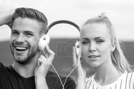 Téléchargez les photos : Couple appréciant la musique. Se détendre à l'extérieur ensemble. Concept de relations - en image libre de droit