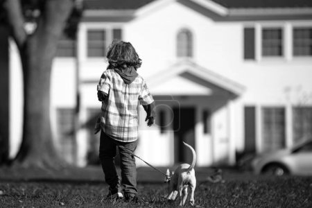 Foto de Un niño jugando con un cachorro. Niño feliz perro paseante - Imagen libre de derechos