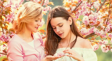 Foto de Banner de primavera con mujeres novias al aire libre. Dos chicas de primavera de belleza con flores sakura cereza Flovers - Imagen libre de derechos