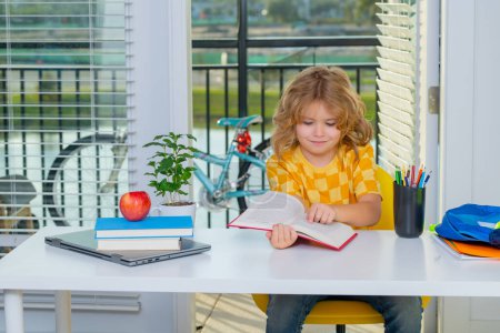 Photo for School kid reading book. School kid 7-8 years old with book go back to school. Little student learning and doing homework. Education at home concept - Royalty Free Image
