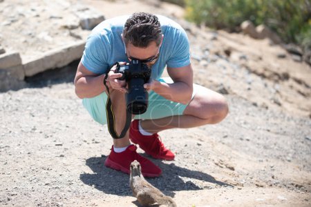 Photo for Funny moments. Man photographer with a large professional camera photograph funny squirrel. Portrait of photographer with camera photograph fun crazy squirrel outdoor. Tourist photographer - Royalty Free Image