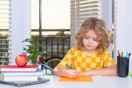 Téléchargez les photos : Enfant de l'école primaire écrivant ses devoirs à la maison. Petite étudiante, intelligente élève nerd prête à étudier. Première fois à l'école. Concept d'éducation et d'apprentissage - en image libre de droit