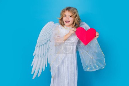 Photo for Child with angel wings hold paper heart. Symbol love and valentines day. Cute angel kid, studio portrait. Blonde curly little angel child with angels wings, isolated background - Royalty Free Image