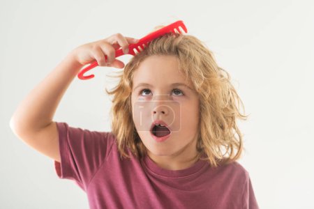 Photo for Funny hairstyle. Kid boy makes face expressions, combing hair. Cute child with comb. Blonde kid combs unruly hair. Kid boy with tangled long hair - Royalty Free Image
