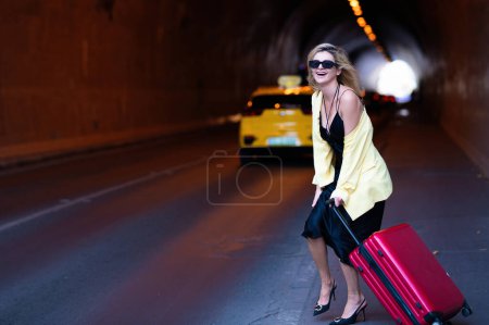 Foto de Travelling concept. Sexy young woman on trip walking with his luggage on street. Sensual girl with travel bag ready to travel on vacation - Imagen libre de derechos