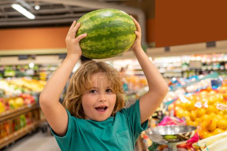 Téléchargez les photos : Enfant avec pastèque. Enfant choisissant des fruits et légumes pendant les achats au supermarché de légumes - en image libre de droit
