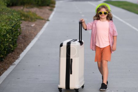 Foto de Niños viajando. Niño con bolsa de viaje listo para viajar en sus vacaciones - Imagen libre de derechos