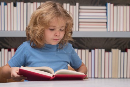 Photo for Pupil with book. Back to school. School kid pupil studying in school library. Child reading book in library on bookshelf background - Royalty Free Image