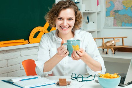 Photo for School teacher eating in classroom. Lunch time. Education concept. Study and learning - Royalty Free Image