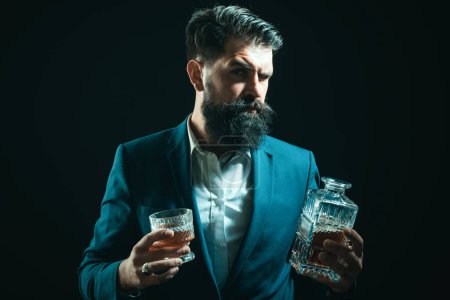Foto de Hombre o hombre de negocios bebe whisky sobre fondo negro. Hombre barbudo alegre está bebiendo whisky caro - Imagen libre de derechos
